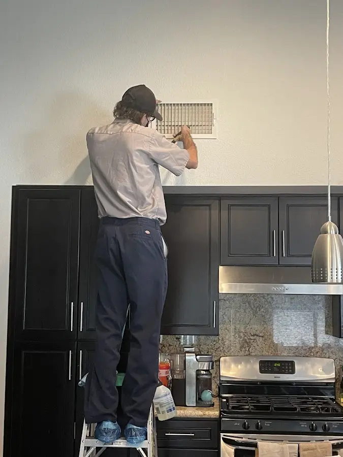 Technician inspecting an air vent during HVAC service in Green River